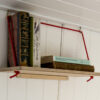 Everything Goes - Hang Shelf - storing books on a sloped boat wall. Birch ply with red rope.